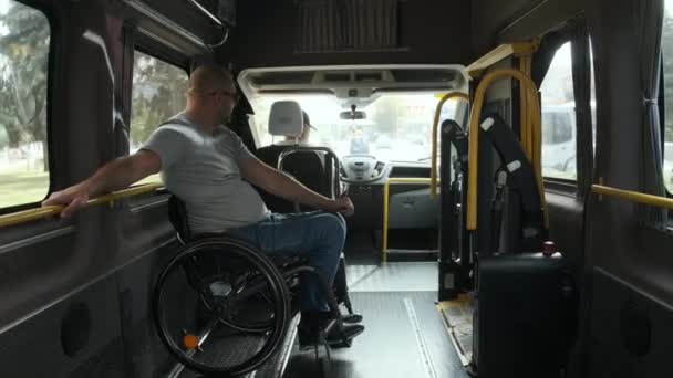 坐在轮椅上的人在专用车里 残疾人由一辆特殊的汽车运送 乘坐专车 公共汽车运送残疾人 — 图库视频影像