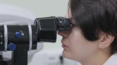 Kadın doktor göz doktorundan göz hekimliği kliniğindeki hastanın gözlerine bakıyor. Uzman vizyon denetimi