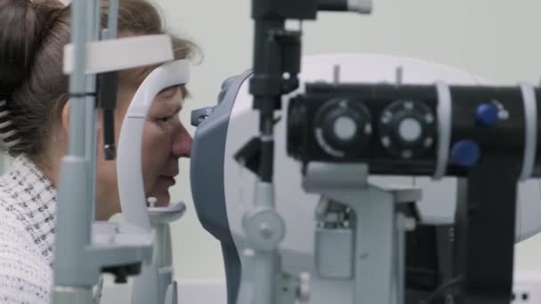 Kobieta Lekarz Patrzy Przez Oftalmoskop Oczach Pacjenta Klinice Okulistycznej Profesjonalna — Wideo stockowe