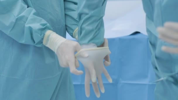 Νοσοκόμα Που Βοηθά Τον Χειρουργό Φορέσει Αποστειρωμένα Γάντια Πριν Την — Αρχείο Βίντεο