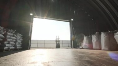 Depoda. Forklift sürücüsü depoya büyük bir çanta dolusu hammadde yığıyor..