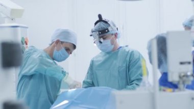 Bademcik ameliyatı, bademcik ameliyatı. Modern klinikte derin anestezi altında, en son cihazları kullanarak hasta bezleri, soğuk plazma metodunu, boğazdaki şişliği, doktor yeni bir sondayla, tıbbi farla çalışıyor.