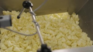 Üretim fabrikası, kızartmadan sonra altın patates cipsi satıyor. Makarna fabrikasının üretim hattı.
