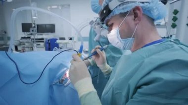Bademcikleri derin anestezi altında çıkarma operasyonu, cerrah en son cihazları kullanır, soğuk plazma yöntemi, boğazda şişme, doktor yeni bir sonda, tıbbi far, cerrahi lenslerle çalışır.