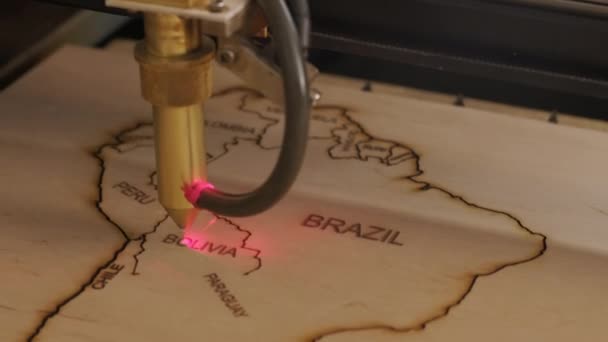 Машина лазерной резки Cnc вырезает карту мира на деревянной доске и фанере — стоковое видео