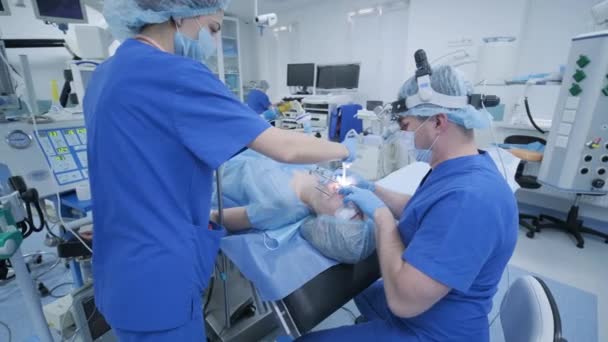 "The anesthesiologist with assistant prepares female patient for surgery — Stock Video