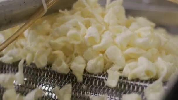 Línea de producción de la fábrica se mueve papas fritas de oro después de freír. Línea de producción de la fábrica de pasta — Vídeos de Stock