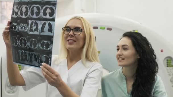 "La radióloga doctora explica los buenos resultados de la tomografía computarizada para pacientes jóvenes — Vídeos de Stock