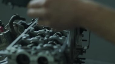 Garajdaki bir oto tamircisi araba motorunun kapağını kapatır. Tamirden sonra tamirci elleri motoru kapatır. Araba servisi.