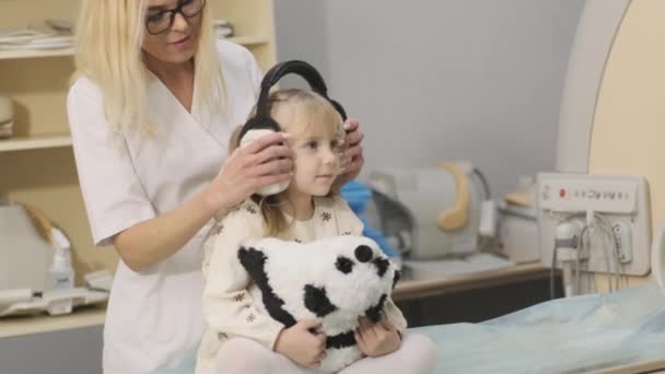 Doctor Radiologist Puts Noise Isolating Headphones Patient Little Girl Make — Stock video