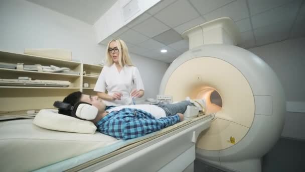 Uma Médica Faz Uma Ressonância Magnética Joelho Paciente Jovem Mesa — Vídeo de Stock