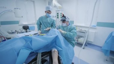 Bademcikleri derin anestezi altında çıkarma operasyonu, cerrah en son cihazları kullanır, soğuk plazma yöntemi, boğazda şişme, doktor yeni bir sonda, tıbbi far, cerrahi lenslerle çalışır.