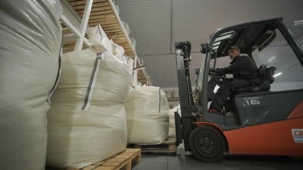叉车司机把一大袋原材料堆放在仓库里 仓库里有许多袋原材料 — 图库视频影像