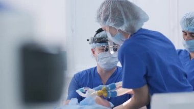 The anesthesiologist with assistants prepares female patient for surgery, puts patient into anesthesia, regulates oxygen mask, endotracheal tube. Surgery. Anesthesia