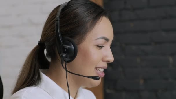 Lachende vrouw call center operator, customer support agent draagt headset raadpleegt klant online, typen op laptop, praten in internet computer chat, hulplijn operator secretaresse te maken conference video call — Stockvideo