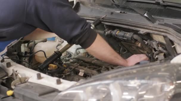 Mecânico de automóveis trabalhando no motor do carro na garagem mecânica. Serviço de reparação. — Vídeo de Stock