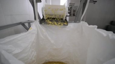 Üretim fabrikası, patates çerezlerini taşıyor. Makarna fabrikasının üretim hattı, makarna üretimi, makarna bir torbaya konur.