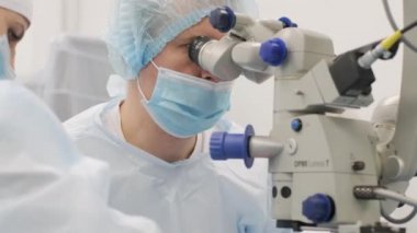 Cerrahi ekibi modern teknolojileri, son cihazları, modern klinikte mikroskobu kullanarak strabismus ameliyatı yapıyor.