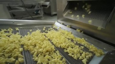 Üretim fabrikası, patates çerezlerini taşıyor. Makarna fabrikasının üretim hattı, makarna üretimi.