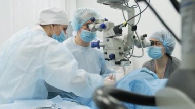 Cerrahi ekibi modern teknolojileri, son cihazları, modern klinikte mikroskobu kullanarak strabismus ameliyatı yapıyor.
