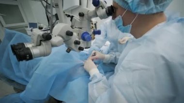 Cerrahi ekibi modern teknolojileri, son cihazları, modern klinikte mikroskobu kullanarak strabismus ameliyatı yapıyor.