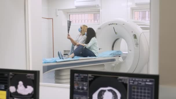 女医生放射学家解释了年轻女性患者的Ct扫描结果 用图像显示了照片的快照 并在现代Ct扫描仪的基础上观察和分析了现代临床的Ct扫描结果 — 图库视频影像