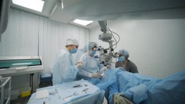 Cerrahi ekibi modern teknolojileri, son cihazları, modern klinikte mikroskobu kullanarak strabismus ameliyatı yapıyor.