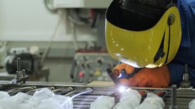 Atölyede maske takan bir adam. Metal işçileri amelelik yapar. Yetenekli kaynakçı. Kaynakçı fabrikadaki paslanmaz çelik boruları kaynaklıyor. Kaynak Sanayi Fabrikası.