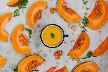 Kupada kabak püresi çorbası ve doğranmış balkabağı ve roka yaprakları. Şükran Günü ya da Cadılar Bayramı kavramı. Düz sonbahar kompozisyonu