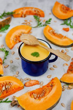 Kupada kabak püresi çorbası ve doğranmış balkabağı ve roka yaprakları. Şükran Günü ya da Cadılar Bayramı kavramı. Düz sonbahar kompozisyonu