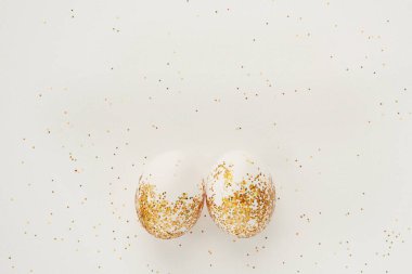 Beyaz arka planda altın parıltısıyla süslenmiş yumurtalar. Paskalya konsepti. Metin için kopyalama alanı olan mutlu paskalya kartları
