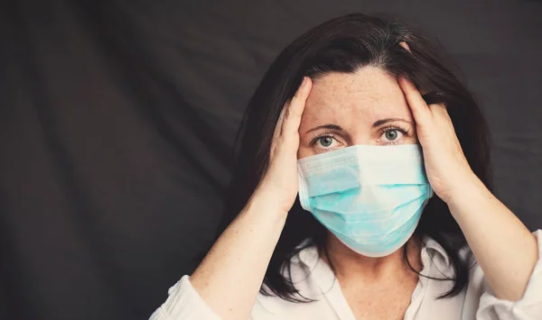 Çilli, koruyucu maskeli, gri saçlı bir kadın kendini karantinaya almak için evde yalnız kalıyor. Depresyon, nevrozlar, korkular, ölüm sonrası sendrom, zihinsel sağlık sorunları, Covid 19 hastalığının sonuçları.