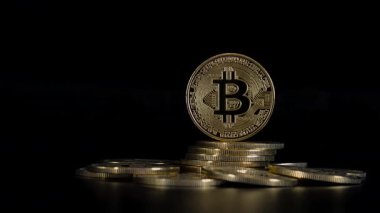 Siyah arka planda altın Bitcoins yığını. Yakın plan bitcoinler. Dolly yavaşça. Şifreli para birimi.