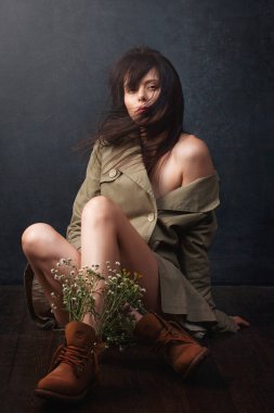 Çekici bir kızın portresi. Ayakkabı içinde yabani çiçekler.