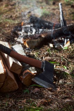 Yakacak odun ve balta şenlik ateşinin yanında.
