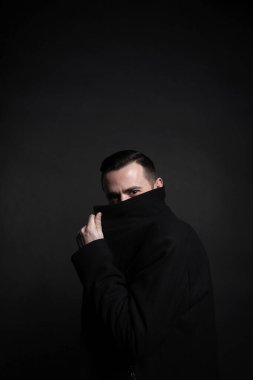 Siyah ceketli şık bir gencin portresi. Siyah arkaplan.