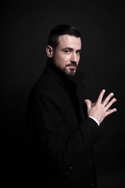 Siyah ceketli şık bir gencin portresi. Siyah arkaplan.