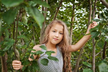 Parktaki ağaçların arasında güzel küçük bir kız