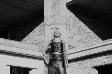 Güzel genç kadın tuğla duvarın yanında 