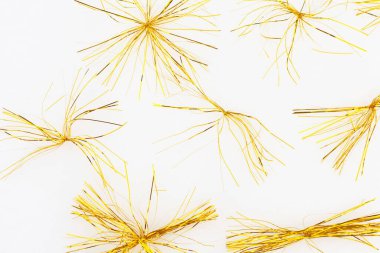 Beyaz arka planda küçük sarı altın süslemeler. Yukarıdan bak. Soyutlama.