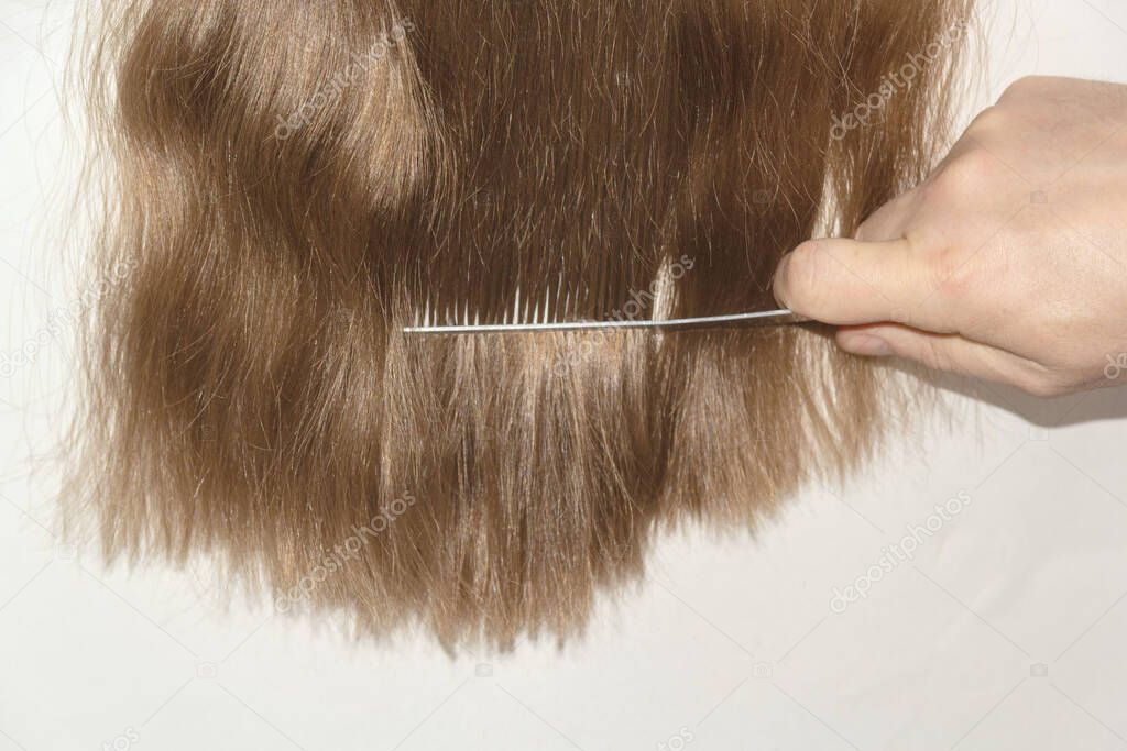 men's hand scissors trim long brown hair to girl or woman.