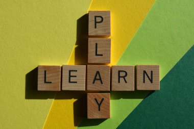 Çal, Öğren, ahşap alfabe harfleriyle yeşil ve sarı arkaplanda izole edilmiş bulmaca şeklinde kelimeler