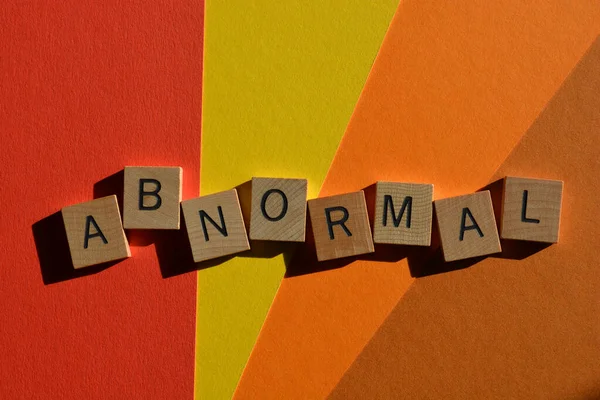 Anormal, ahşap alfabe harflerindeki kelime renkli arkaplanda izole edilmiş.