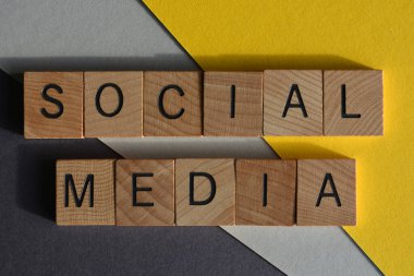 Sosyal medya, ahşap alfabe harflerindeki kelimeler sarı ve gri arkaplanda izole edilmiş.