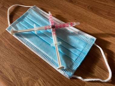 Tıbbi malzemeler, şırıngalar cerrahi maske ile kesişmiş.