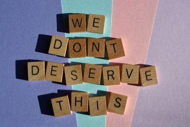 Bunu hak etmiyoruz, arka planda izole edilmiş ahşap alfabe harfleriyle yazılmış kelimeler.