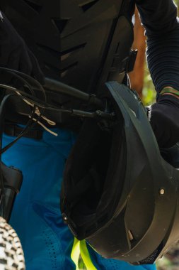 Kaskın ayrıntıları ve dağ bisikletiyle Latin bir motorcunun gidonu.