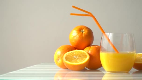 Sok Pomarańczowy Szklance Otoczony Naturalnymi Pomarańczami Naturalnym Słońcem Jasnobiałym Tłem — Wideo stockowe