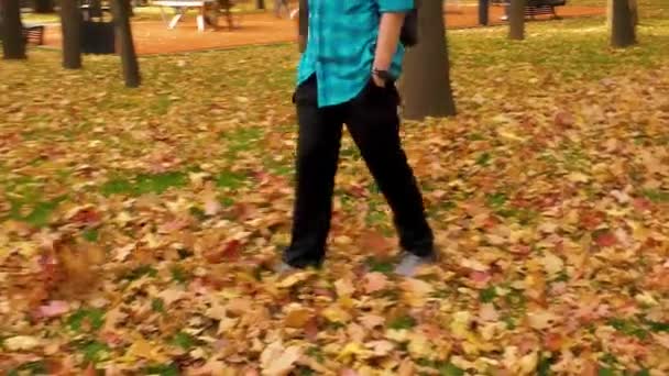 수컷의 공원에서 찹니다 남자는 파란색 셔츠와 바지를 있습니다 — 비디오