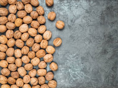 Sert beton zemin üzerinde kabuklu ceviz yatıyordu. Fındıklar arka planın yarısını kaplıyor. Boşluğu kopyala.